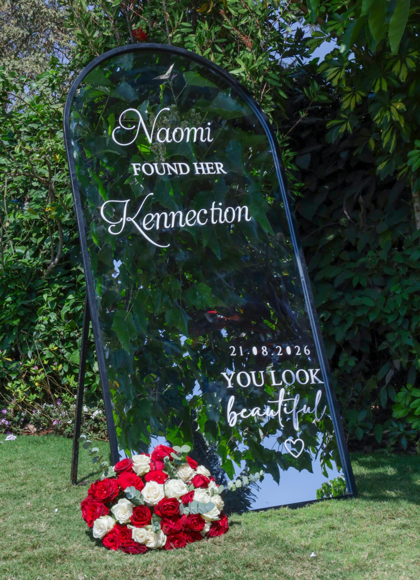 Floral mirror welcome sign displayed in the garden