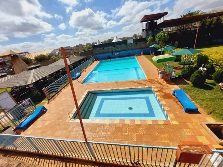 Swimming pool and children's pool with paved terrace, sun umbrellas and lawn