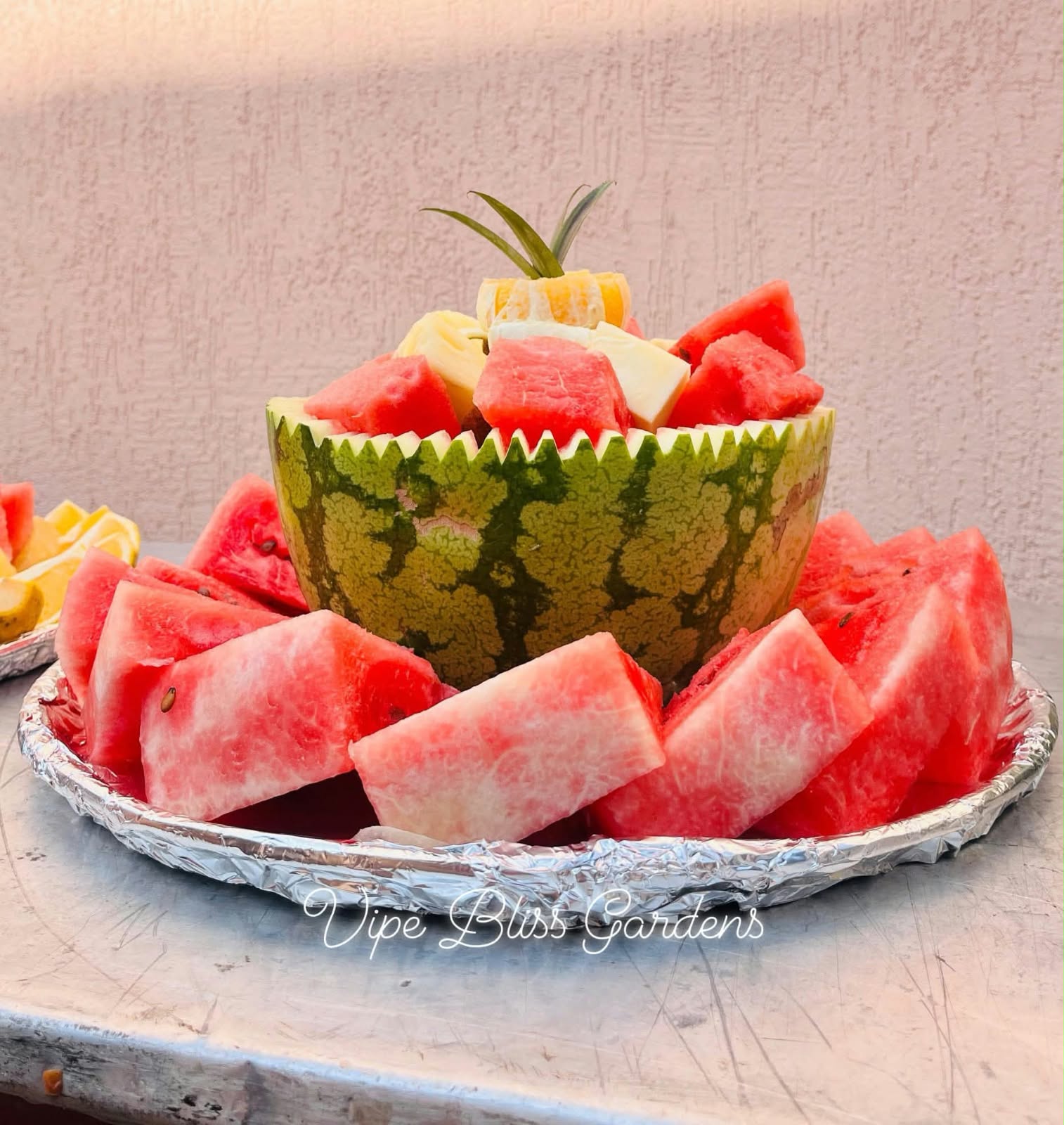 Watermelon pieces arranged around a carved watermelon serving bowl